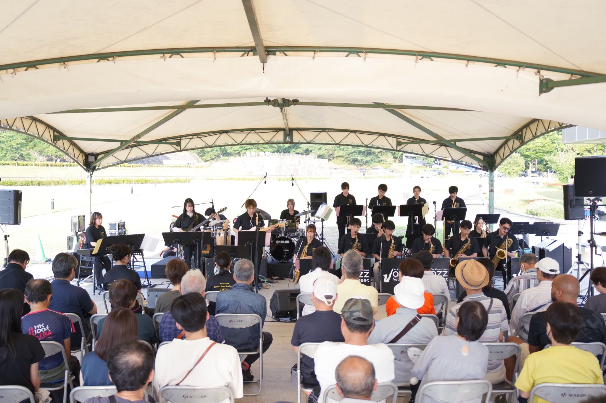 屋外会場で観客に演奏を届けるバンド